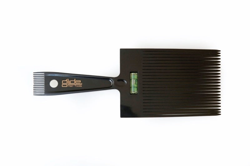 A black flat top comb with a level indicator on the handle.