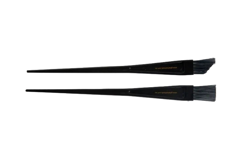 Two black tint brushes for hair colouring laid out on a white background.