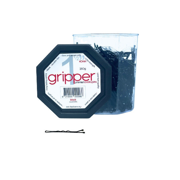 Container of black hair pins with a single pin in front on a white background