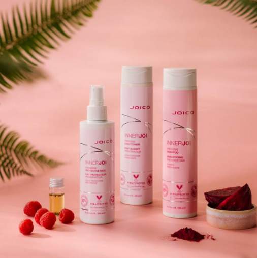 Joico hair care products on a pink background with natural elements