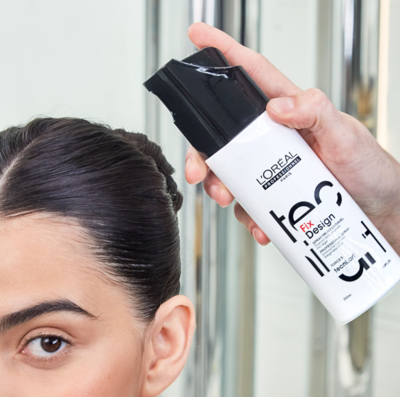 Person applying L'Oreal tecni art Fix+ Design hair product to their hair.