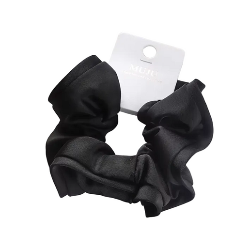 Black scrunchie with a brand tag on a light surface