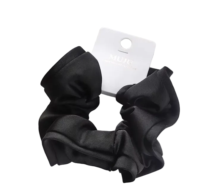 Black scrunchie with a brand tag on a light surface