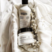 L'Oreal Metal Detox shampoo and mask set on a soft fabric background with decorative elements.