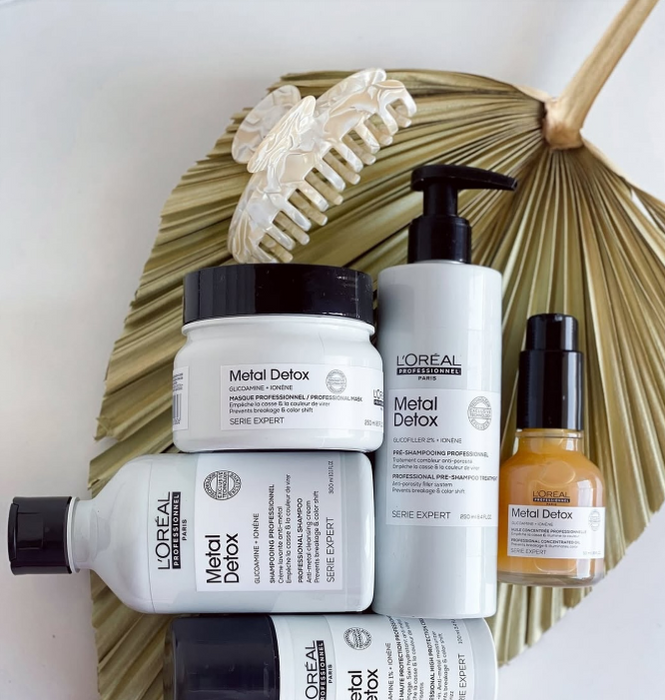 L'Oreal Metal Detox hair care products on a white background with a decorative leaf