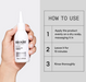 Nioxin hair treatment bottle held by a hand with usage instructions on a gray background