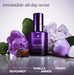 Pureology Love Luster Eau de Parfum bottle in a deep purple shade, styled with purple peony flowers, green leaves, and a vanilla bean on a reflective surface against a light background. Text overlays describe the scent notes.