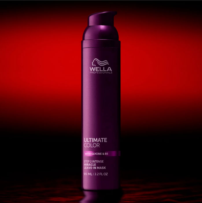 A single Wella Professionals Ultimate Color hair developer bottle in a metallic purple color, standing upright against a dramatic red and black gradient background.