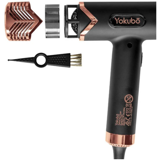 Black and rose gold hair dryer with attachments on a white background
