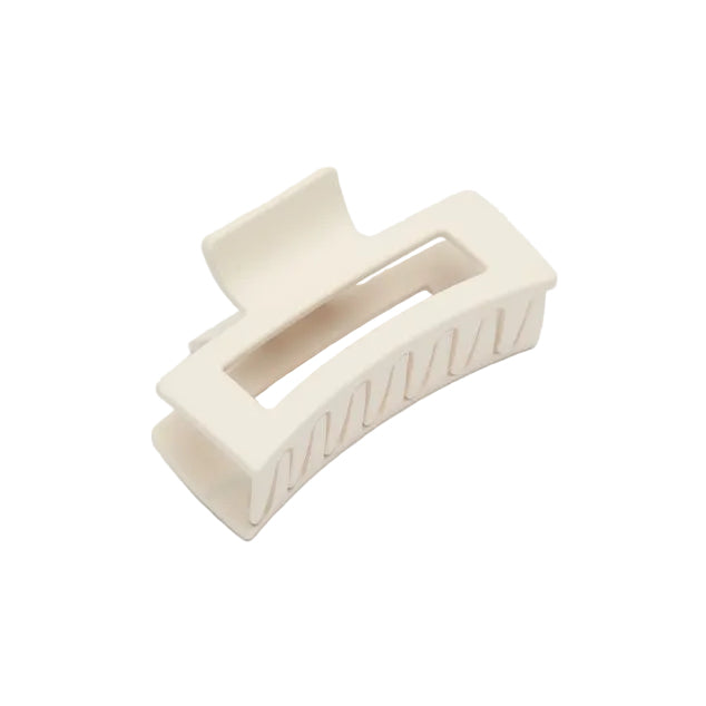 A cream-colored plastic claw hair clip on a light gray background.